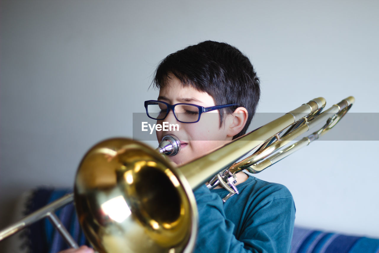 Boy playing trombone at home