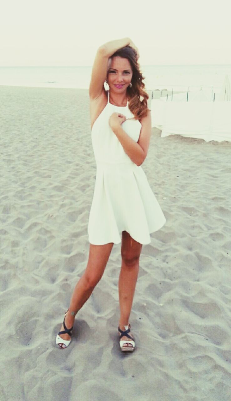 WOMAN STANDING ON BEACH