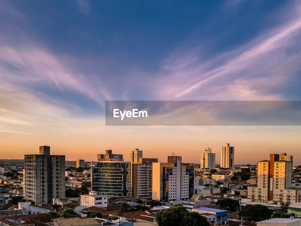 MODERN BUILDINGS AGAINST SKY AT SUNSET