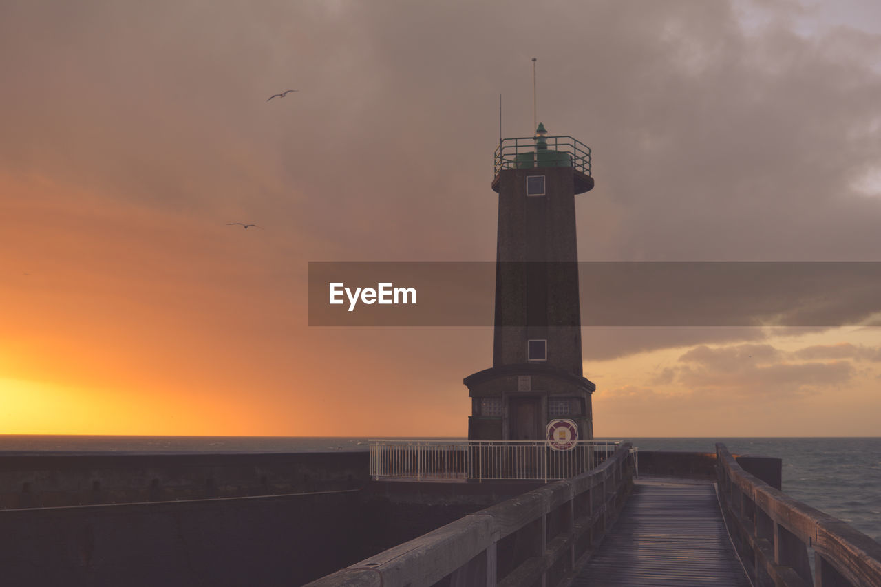 Pier on sea at sunset