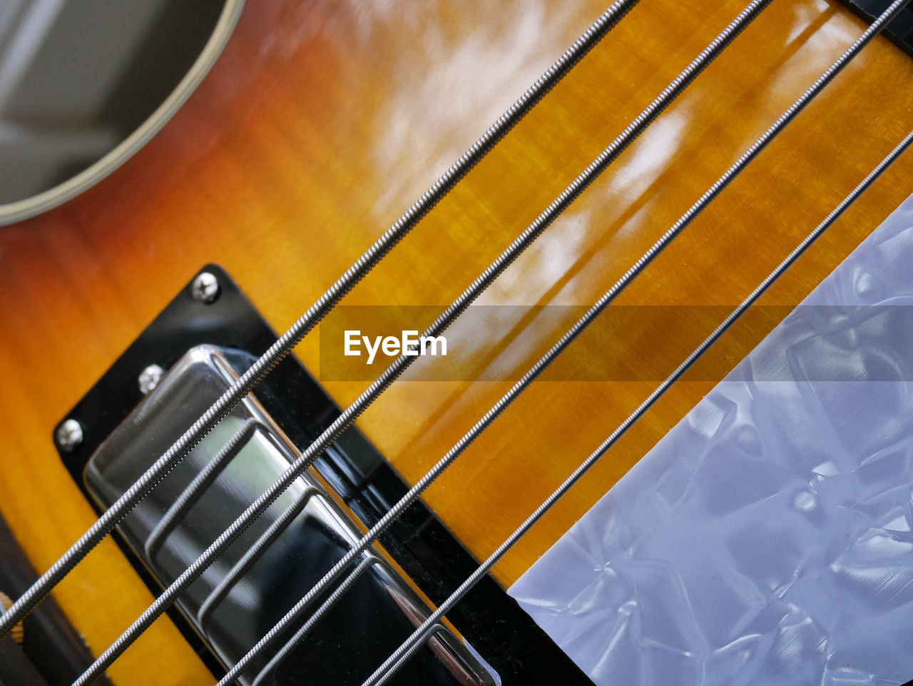 HIGH ANGLE VIEW OF GUITAR ON METAL