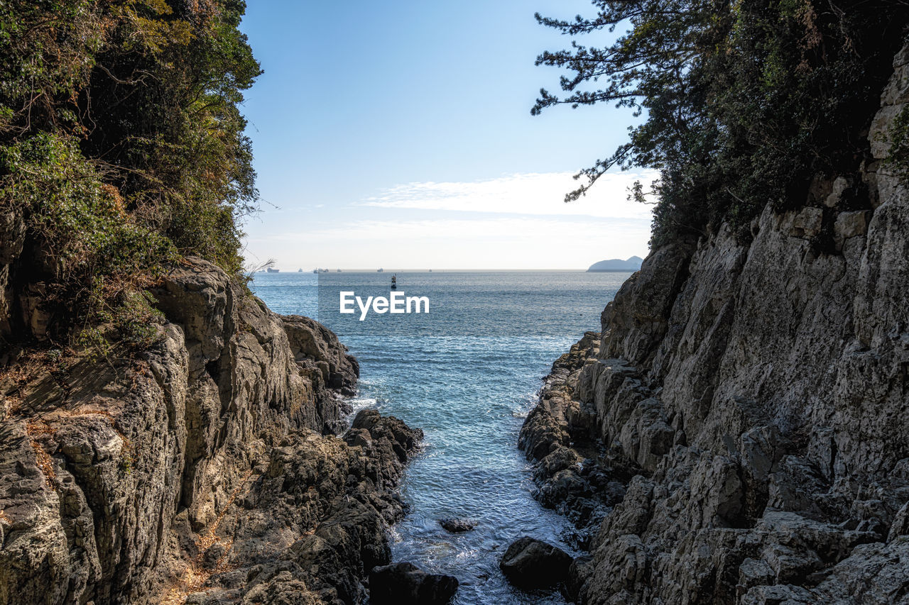 PANORAMIC SHOT OF ROCKS ON SEA AGAINST SKY