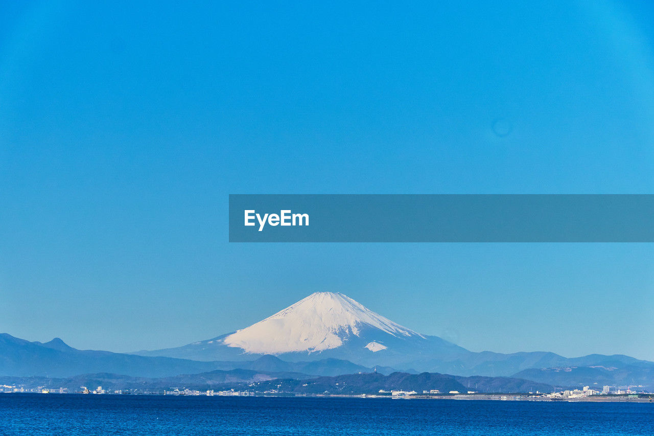 Scenic view of snowcapped mountains against clear blue sky