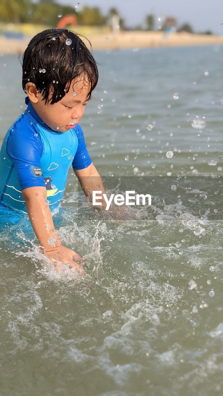 BOY ENJOYING IN SEA