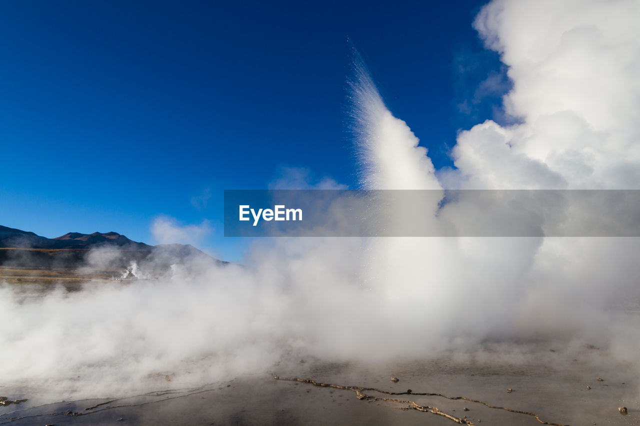 Water splashing against blue sky