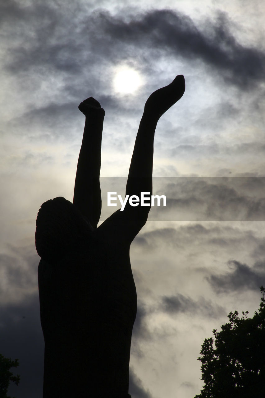 LOW ANGLE VIEW OF SILHOUETTE PERSON HAND AGAINST SKY