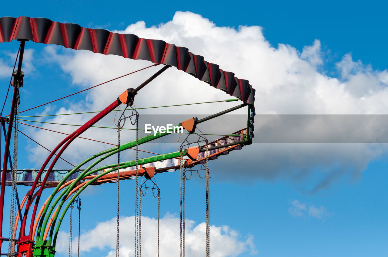 Low angle view of amusement park against blue sky