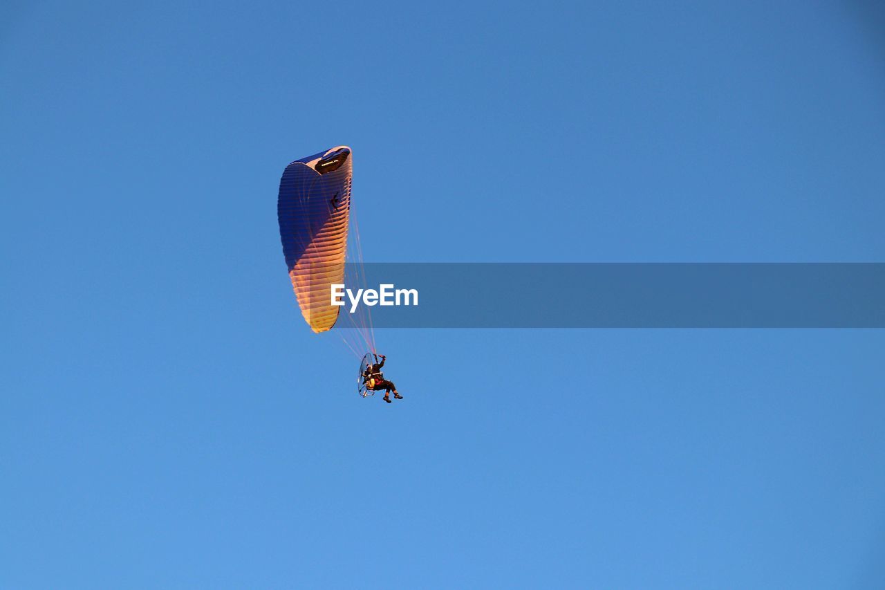 LOW ANGLE VIEW OF PERSON PARAGLIDING AGAINST SKY