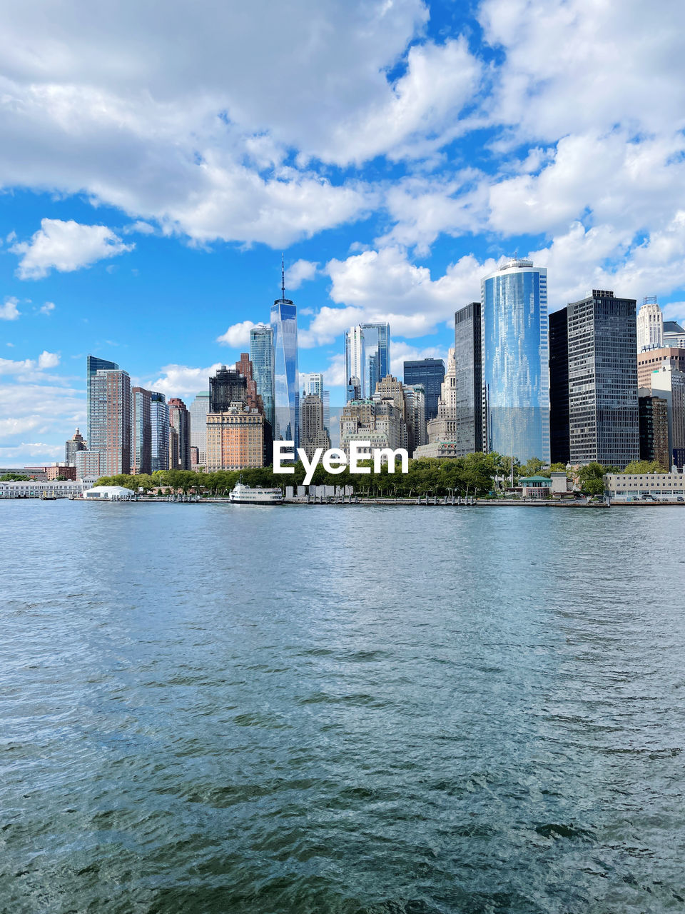 RIVER AMIDST BUILDINGS IN CITY AGAINST SKY