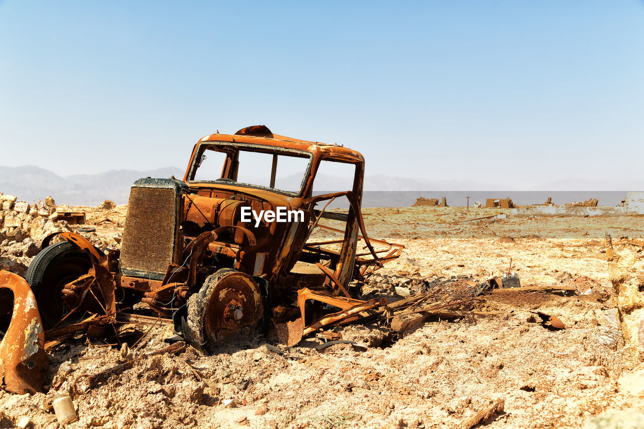 OLD MACHINERY ON LAND AGAINST SKY