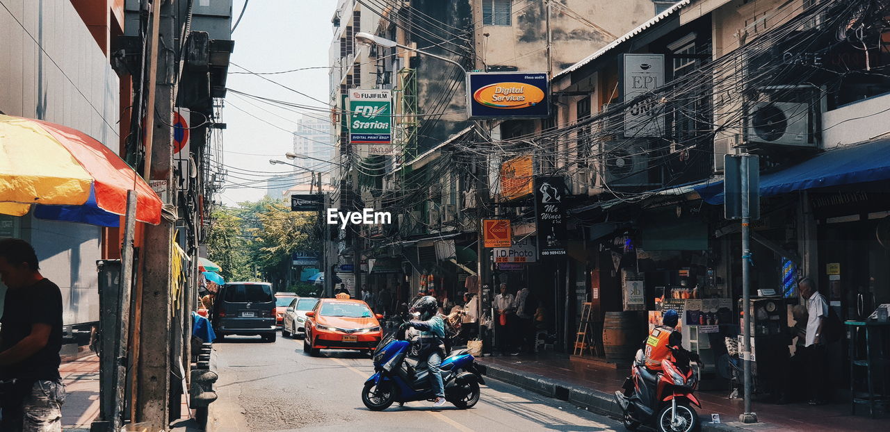 VEHICLES ON CITY STREET AMIDST BUILDINGS