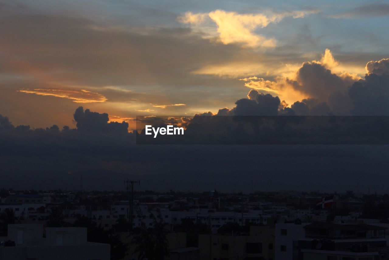 VIEW OF CITYSCAPE AGAINST CLOUDY SKY