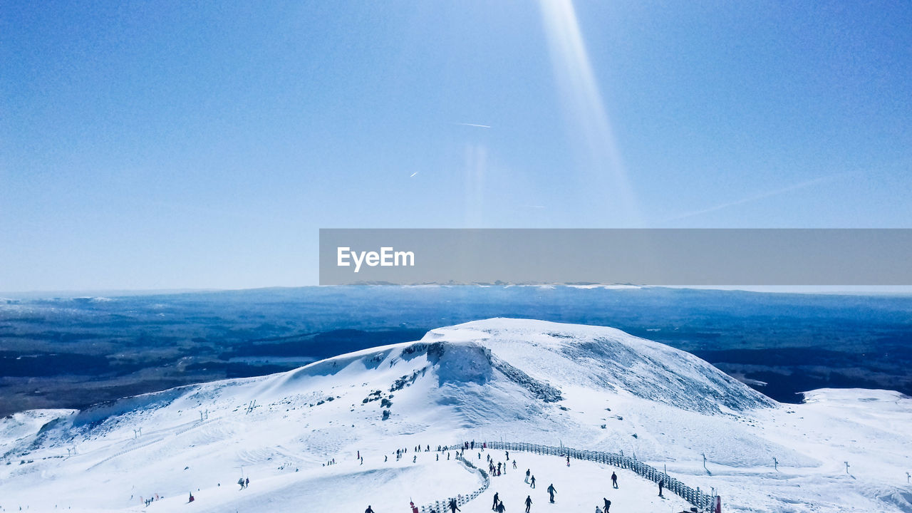 Scenic view of snowcapped mountains against clear blue sky