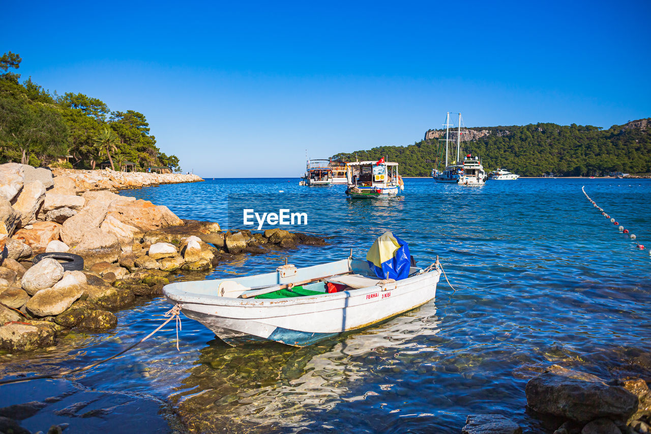 boats in sea against clear blue sky