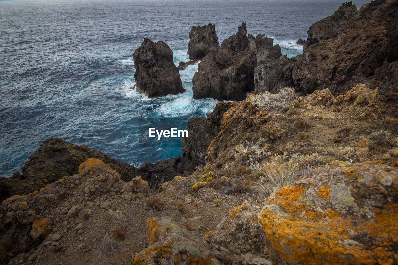 Scenic view of sea by cliff