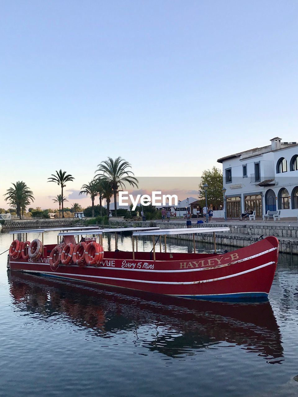 BOAT MOORED IN WATER AGAINST CLEAR SKY