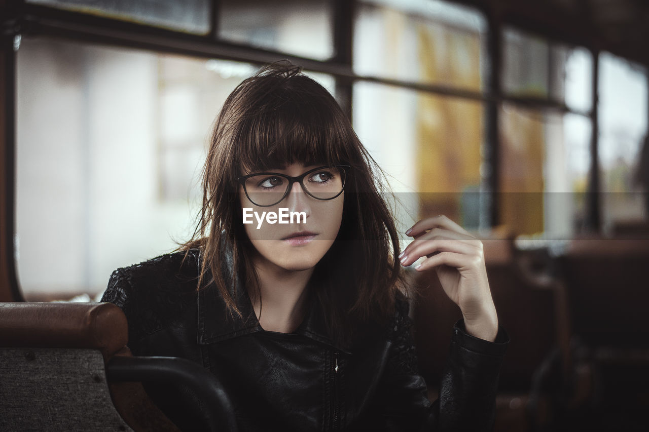 Woman looking away while sitting in bus