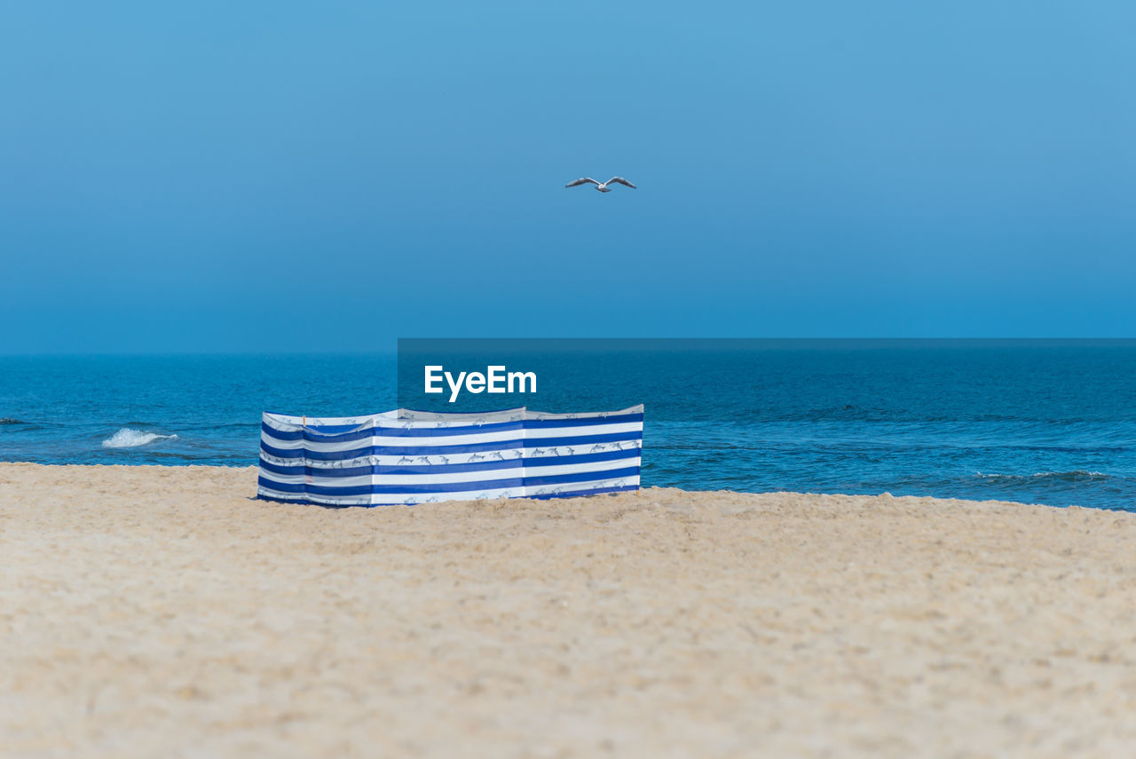 Beach screen on the polish beach on a sunny summer day in the background beautiful sea and gulls.