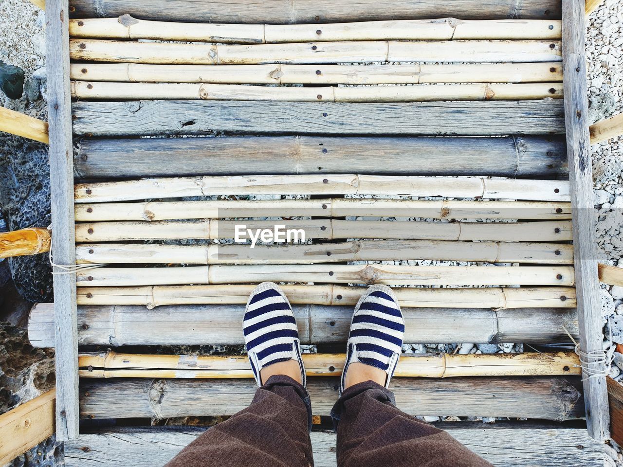 Low section of man standing on footbridge