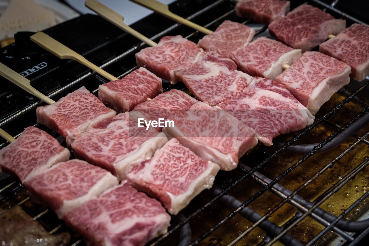 HIGH ANGLE VIEW OF MEAT COOKING ON BARBECUE