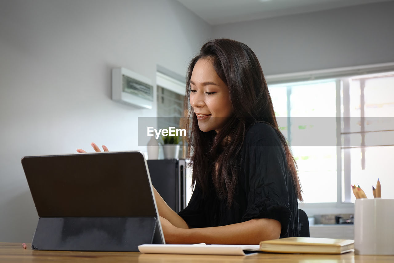 Young woman using digital table on table