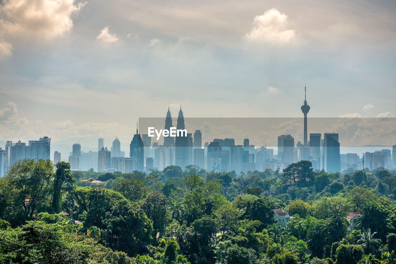 View of cityscape against cloudy sky