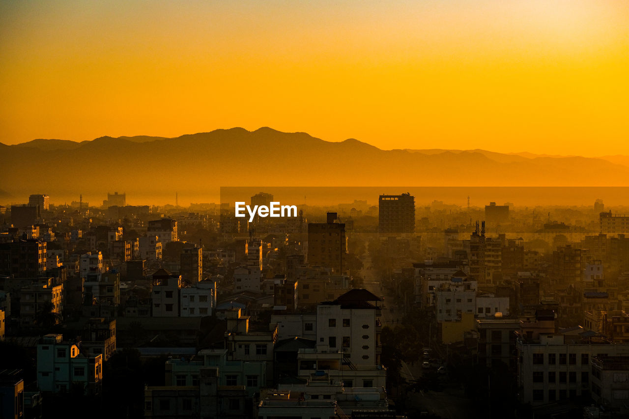 Cityscape against sky during sunrise.