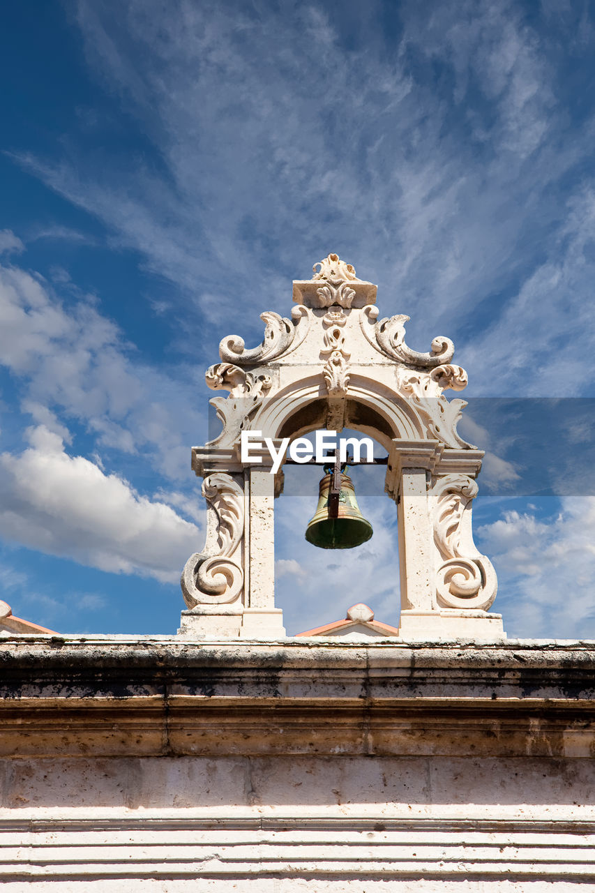 LOW ANGLE VIEW OF STATUE AGAINST BUILDING AGAINST SKY