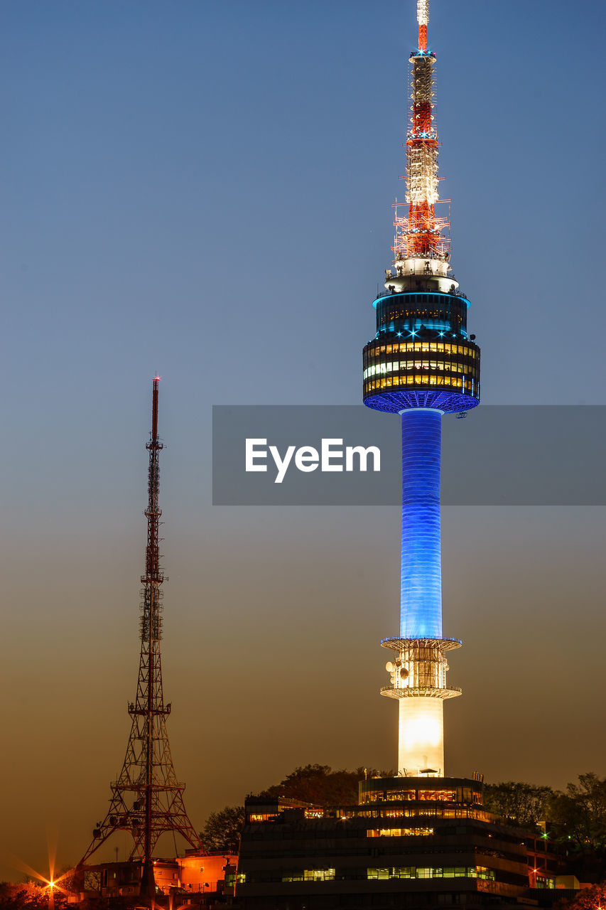 Low angle view of illuminated n seoul tower against sky during sunset
