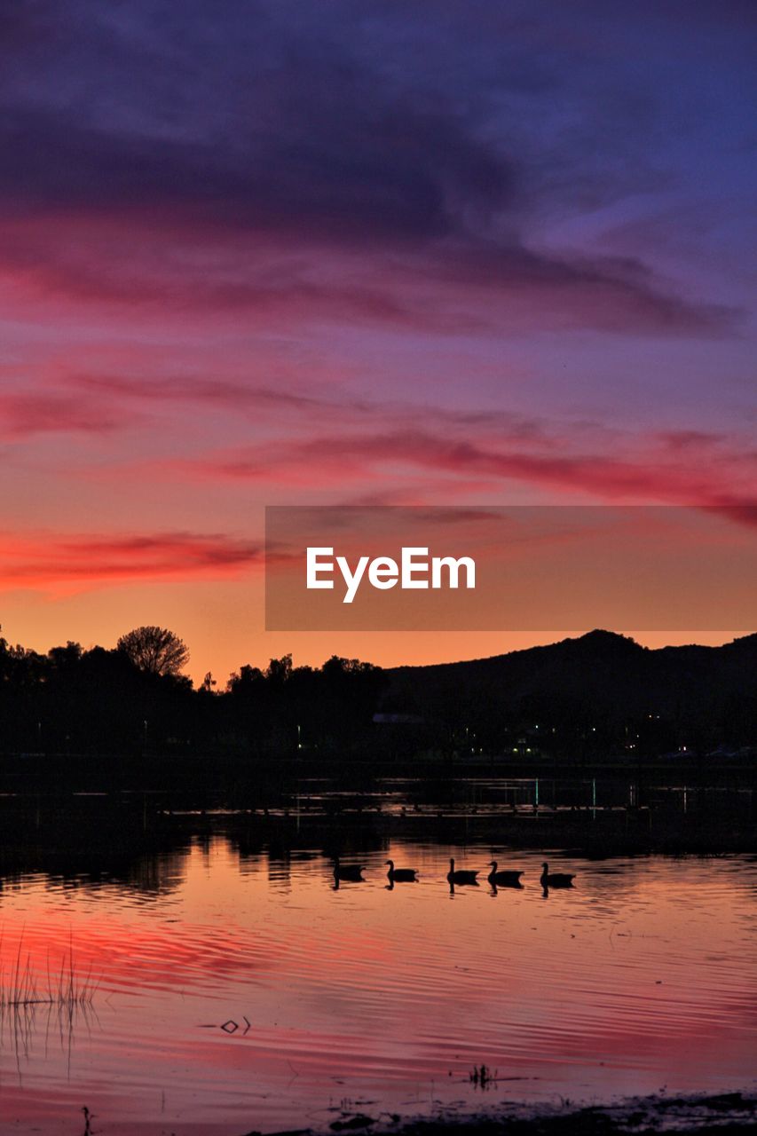 SCENIC VIEW OF LAKE AGAINST ORANGE SKY