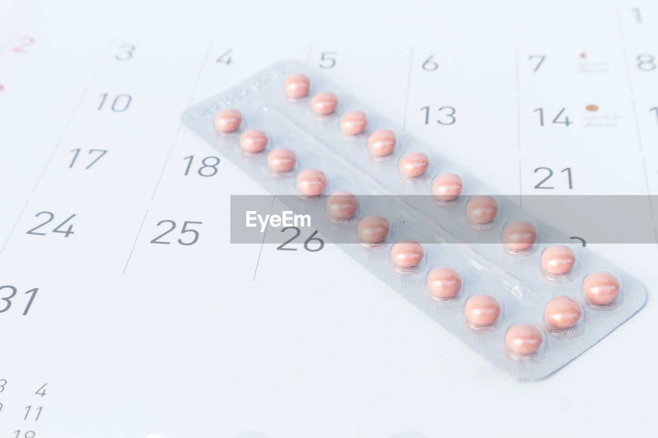 Close-up of pills on calendar
