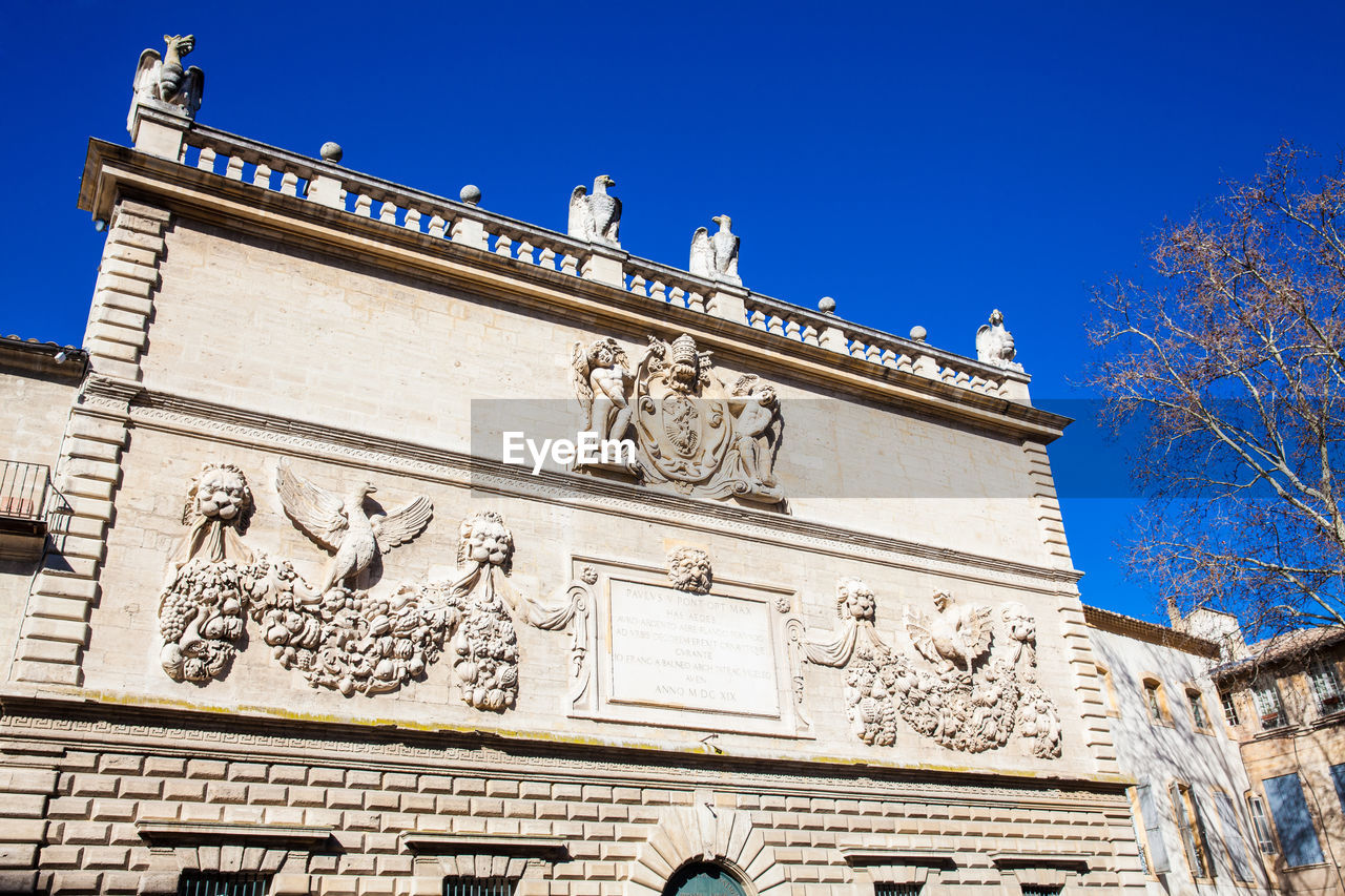 LOW ANGLE VIEW OF STATUES ON BUILDING AGAINST SKY