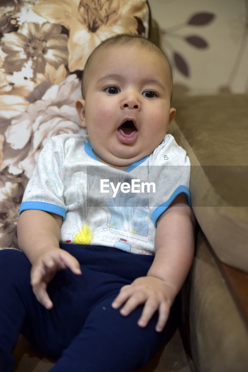 BABY BOY SITTING ON BED