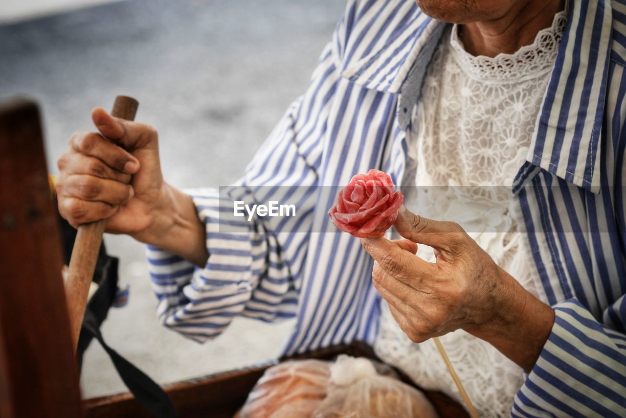 midsection of man holding drink at table