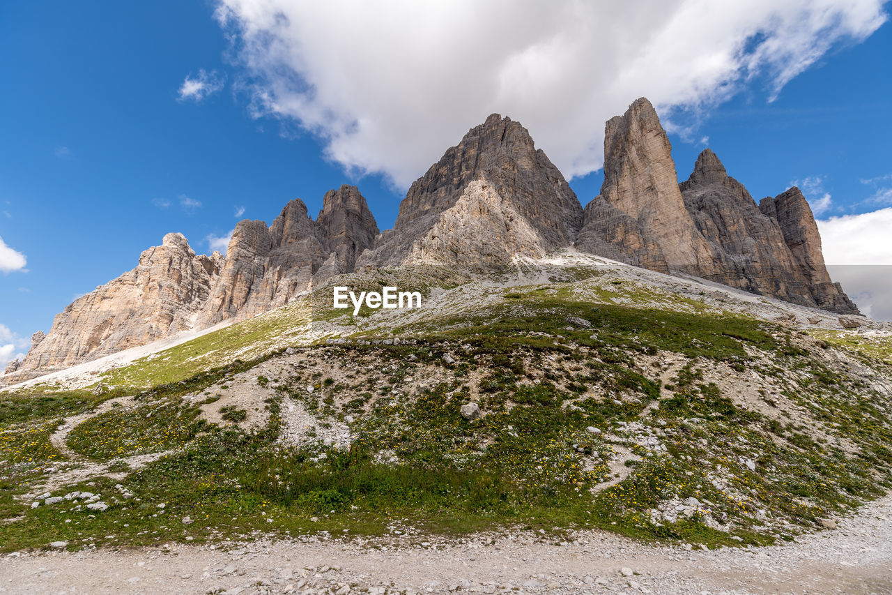 LOW ANGLE VIEW OF MAJESTIC MOUNTAINS AGAINST CLOUDY SKY