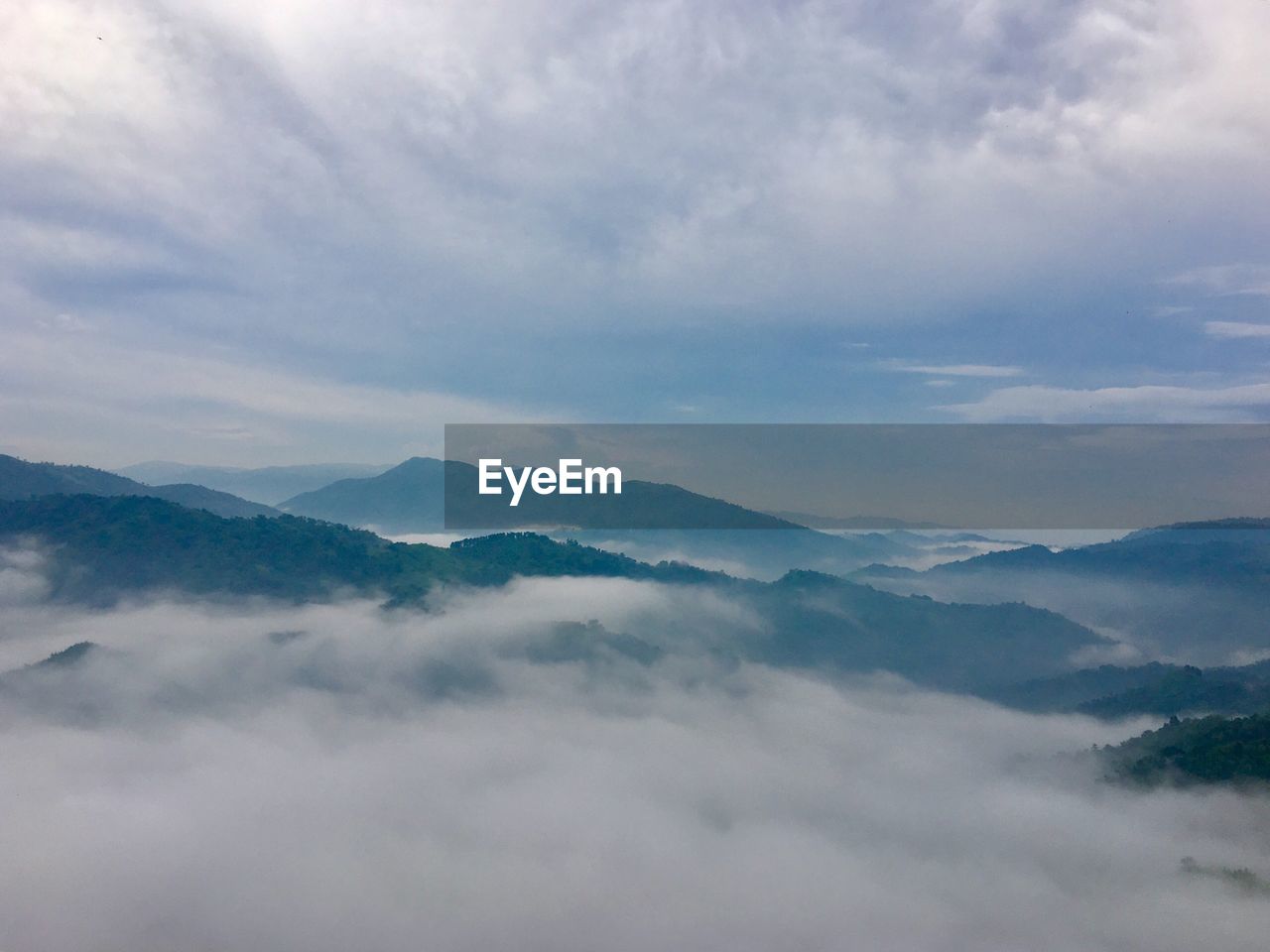 Scenic view of mountains against cloudy sky