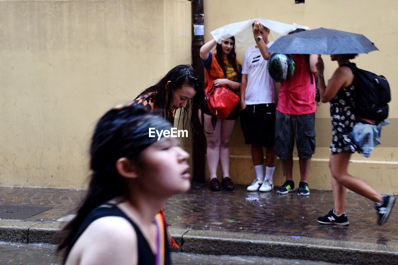 PEOPLE STANDING IN WET RAINY SEASON