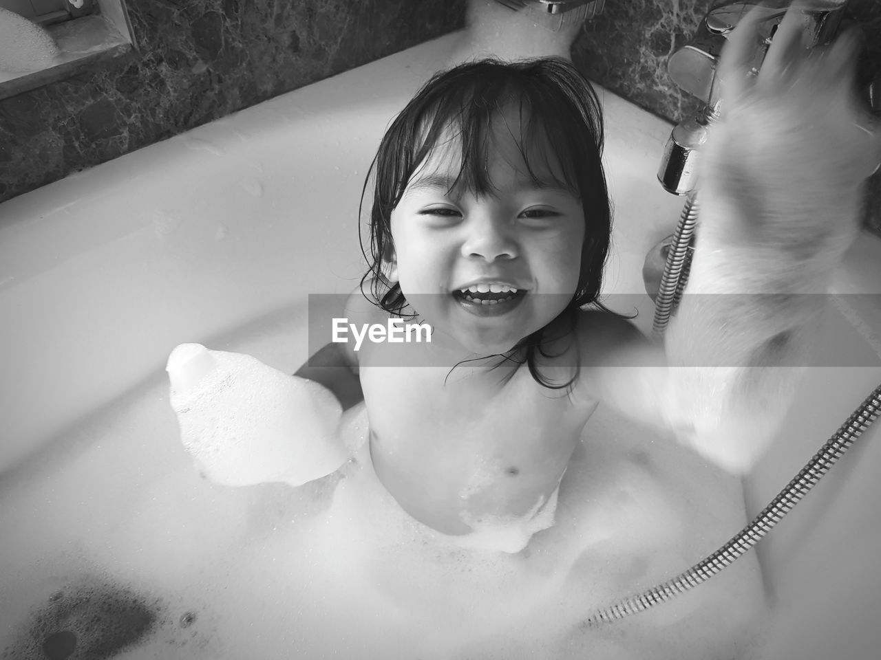 Portrait of shirtless cheerful girl in bathtub