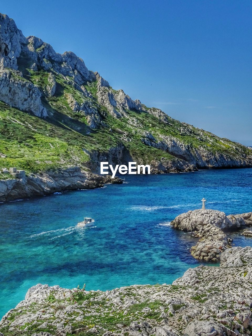 Scenic view of sea and mountains against blue sky