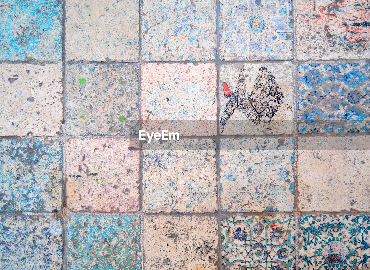 Old weathered turkish tiles with silhouettes of dervishes. traditional turkish patterns. 