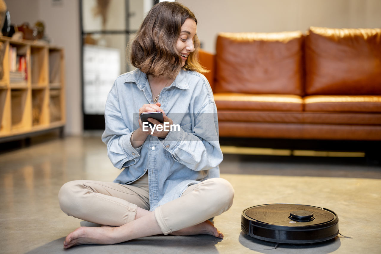 MAN LOOKING AT CAMERA WHILE SITTING ON SOFA