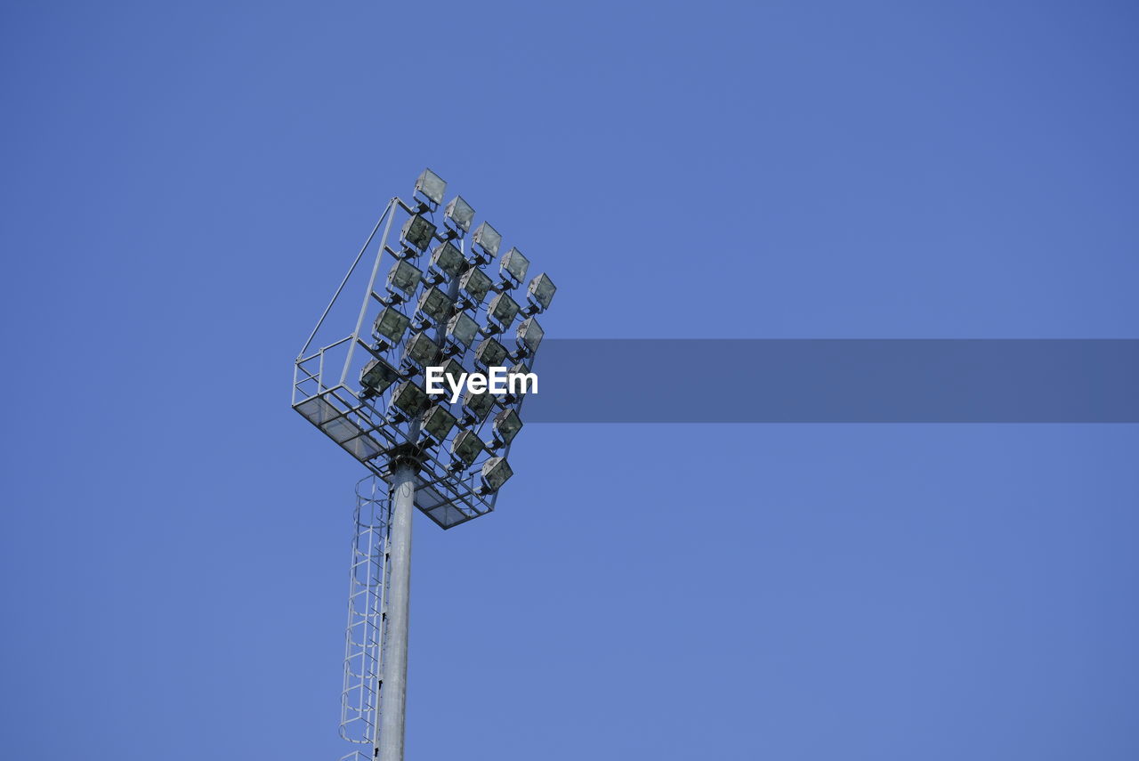 Low angle view of communications tower against blue sky