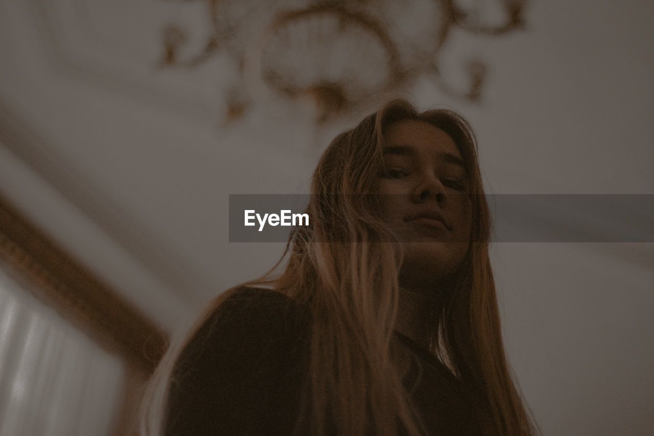 Low angle portrait of young woman at home