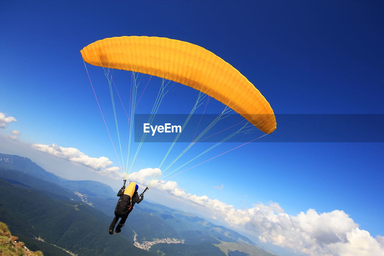 Rear view of one person paragliding over mountains