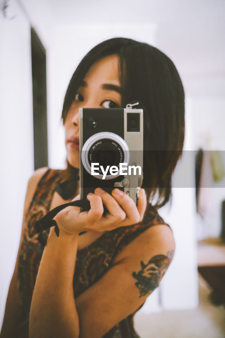 portrait of woman photographing with camera