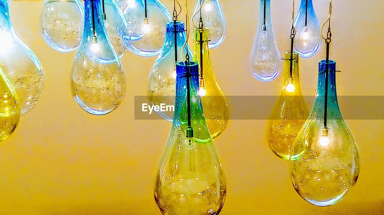 CLOSE-UP OF BOTTLES HANGING IN GLASS