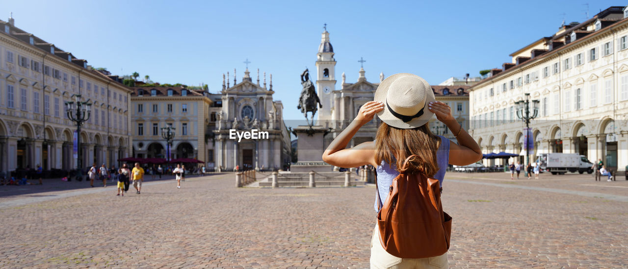 Traveler girl walking in piazza san carlo square enjoying cityscape of turin, italy