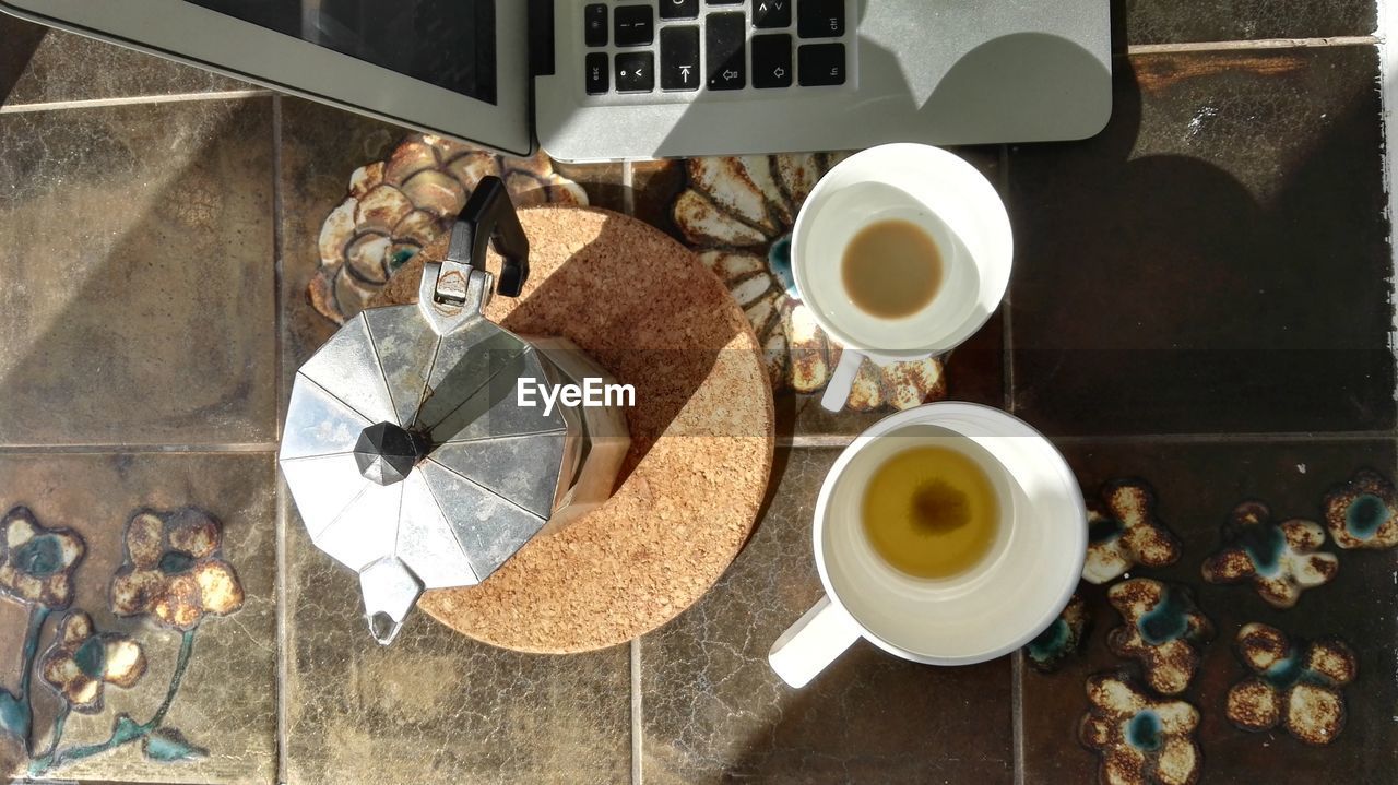 High angle view of two cups of tea with kettle