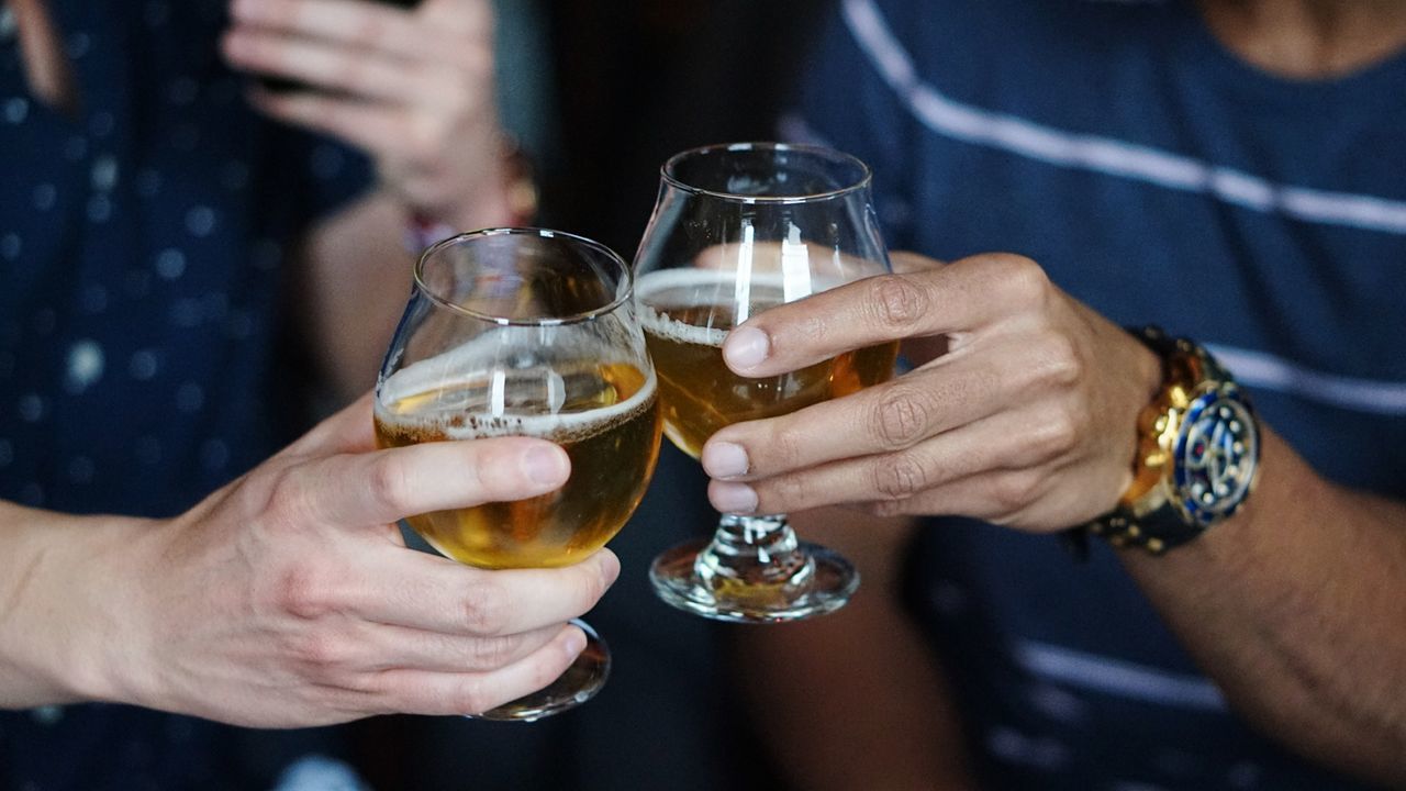CLOSE-UP OF HAND HOLDING BEER GLASS