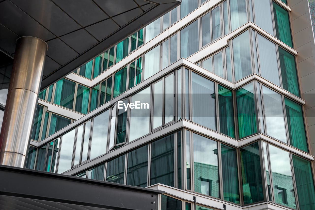 LOW ANGLE VIEW OF GLASS BUILDING IN CITY